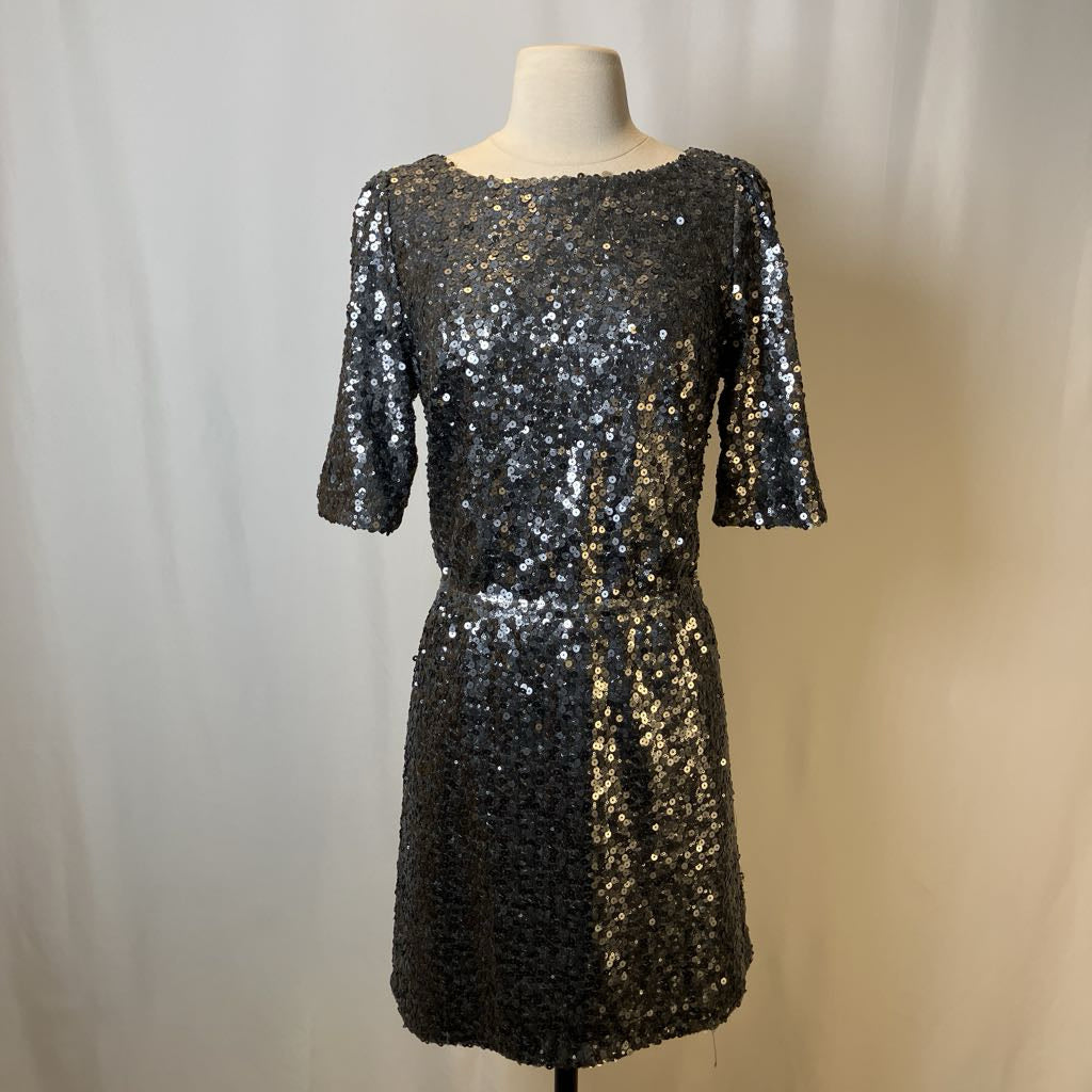 Black sequin dress on a mannequin against a plain background
