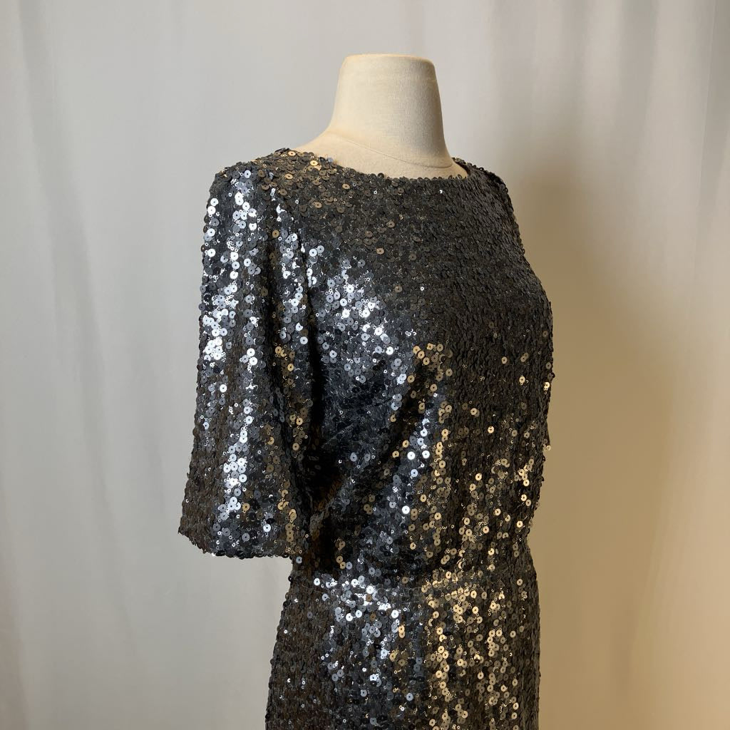 Black sequin dress on a mannequin against a neutral background