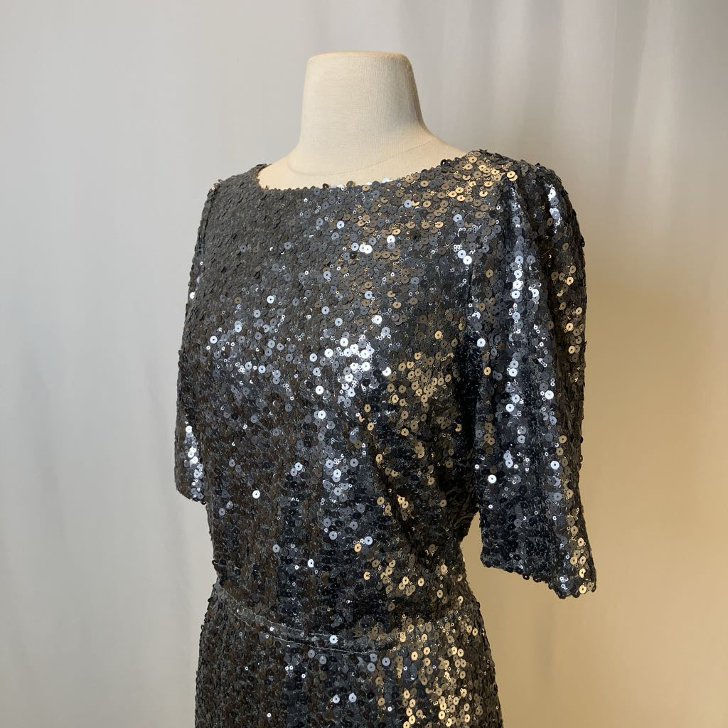 Black sequin dress on a mannequin against a neutral background
