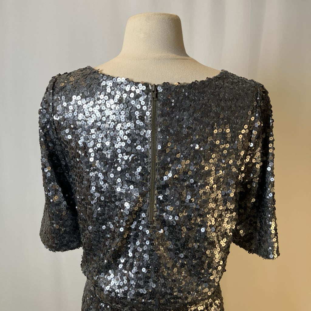 Black sequin top on a mannequin against a neutral background
