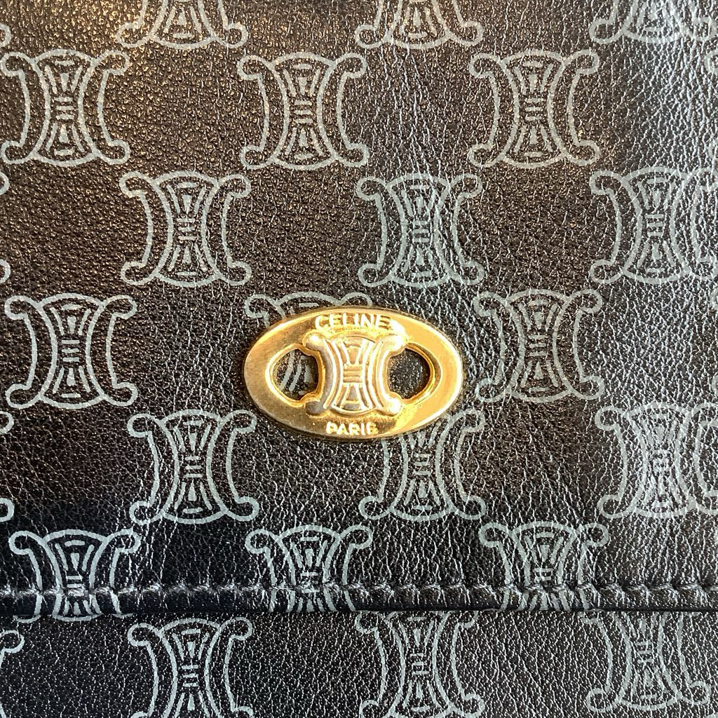 Close-up of a gold Celine logo on a patterned background
