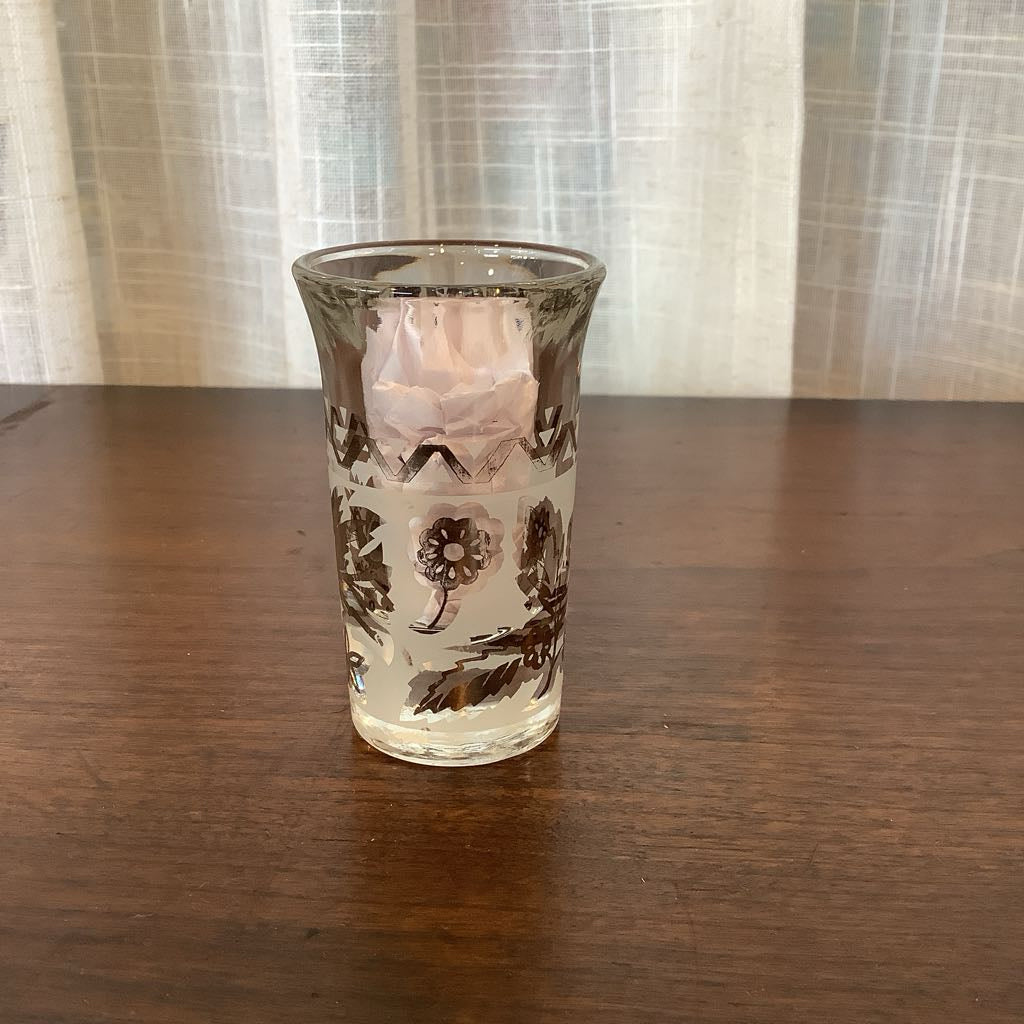 Decorative glass with floral patterns on a wooden surface