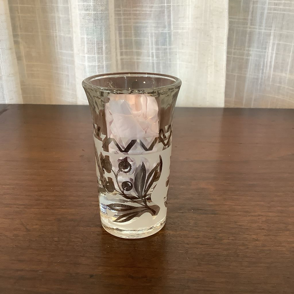 Decorative glass with floral patterns on a wooden surface