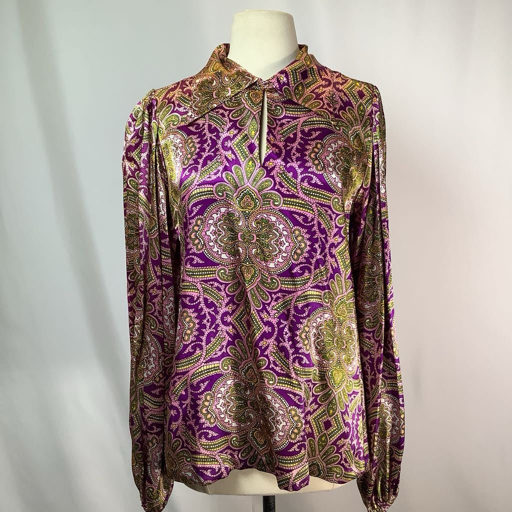 Purple patterned blouse on a mannequin against a white background
