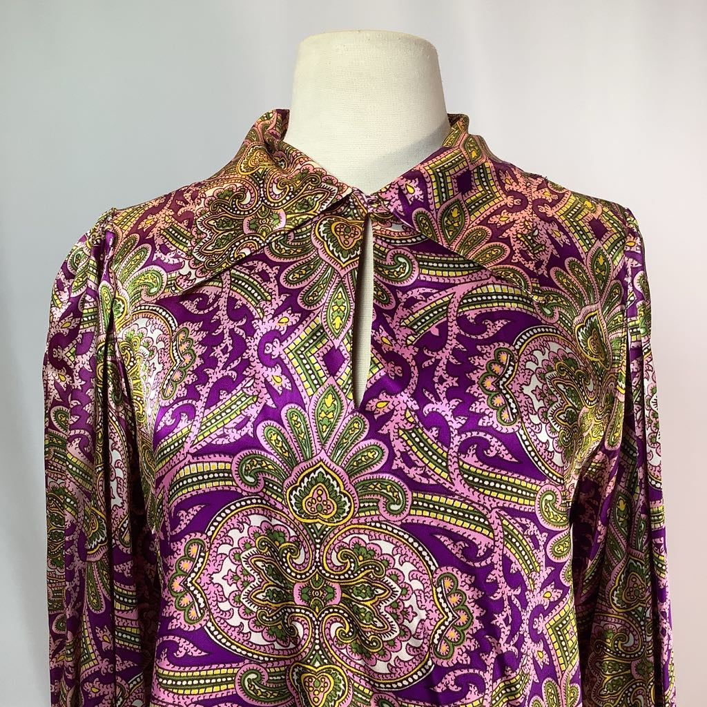 Mannequin wearing a purple patterned shirt with a plain background