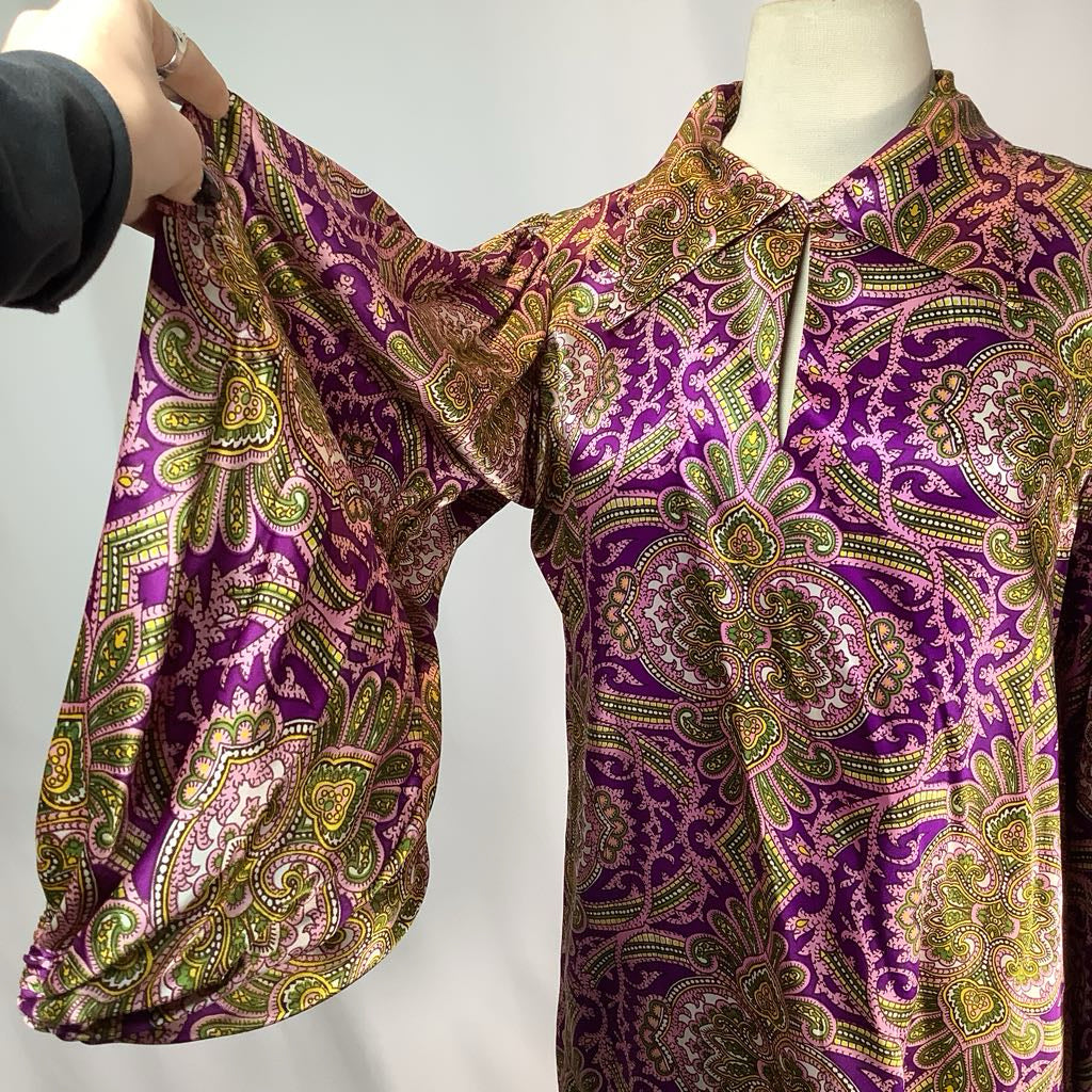 Purple and gold patterned shirt on a mannequin against a white background