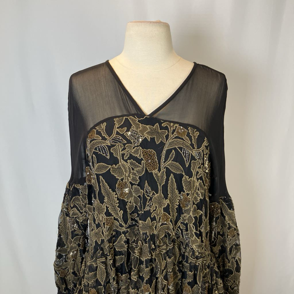 Black dress with gold embroidery on a mannequin against a white background