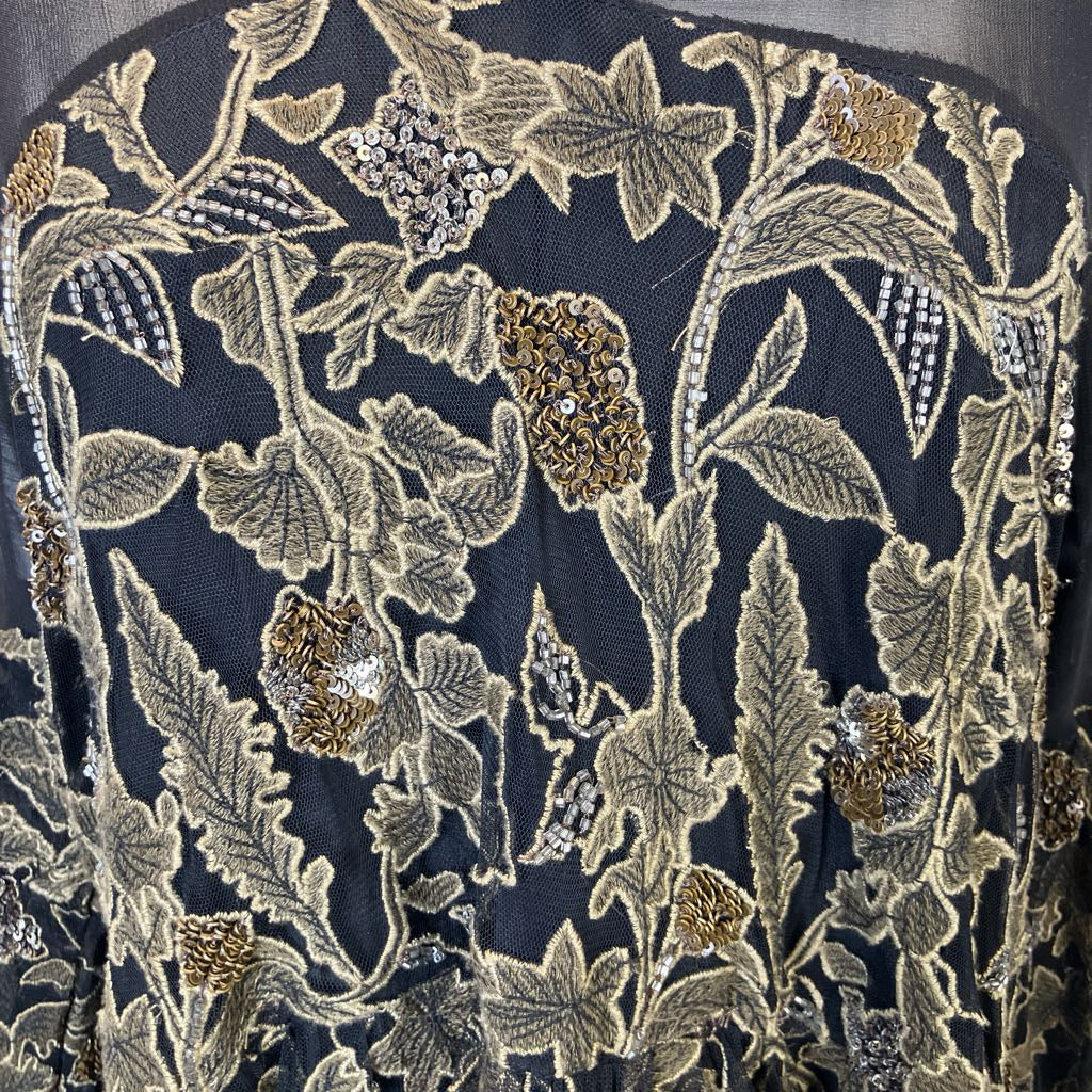 Close-up of floral embroidery with sequins on a dark fabric background