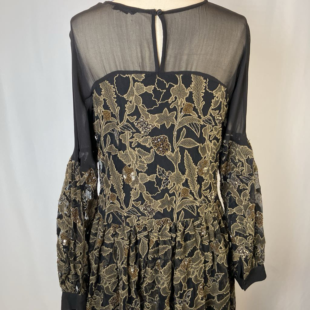 Black dress with gold floral embroidery on a plain background