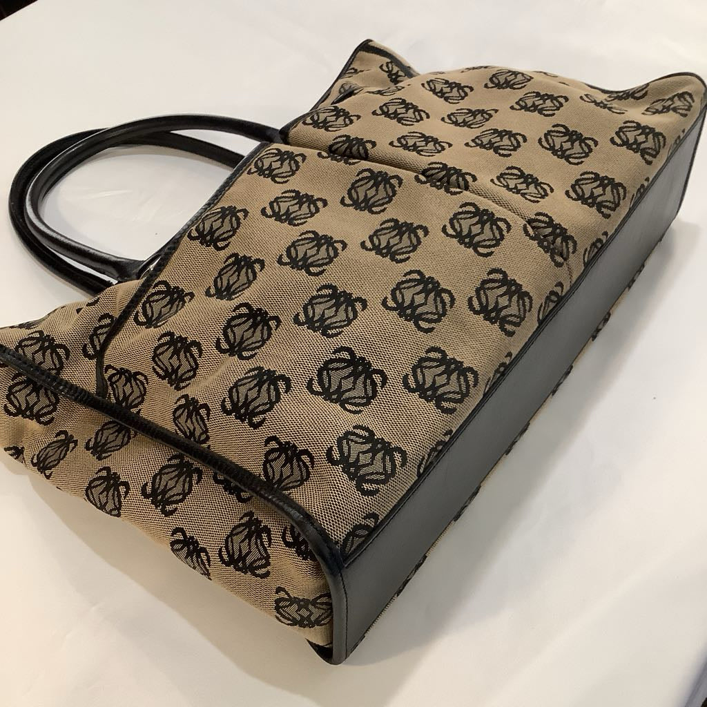 Patterned handbag with black handle on a white background