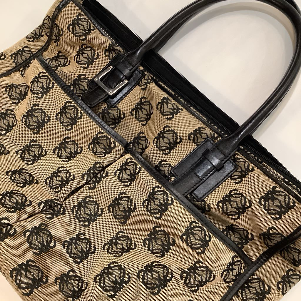 Close-up of a beige bag with black pattern and black handle