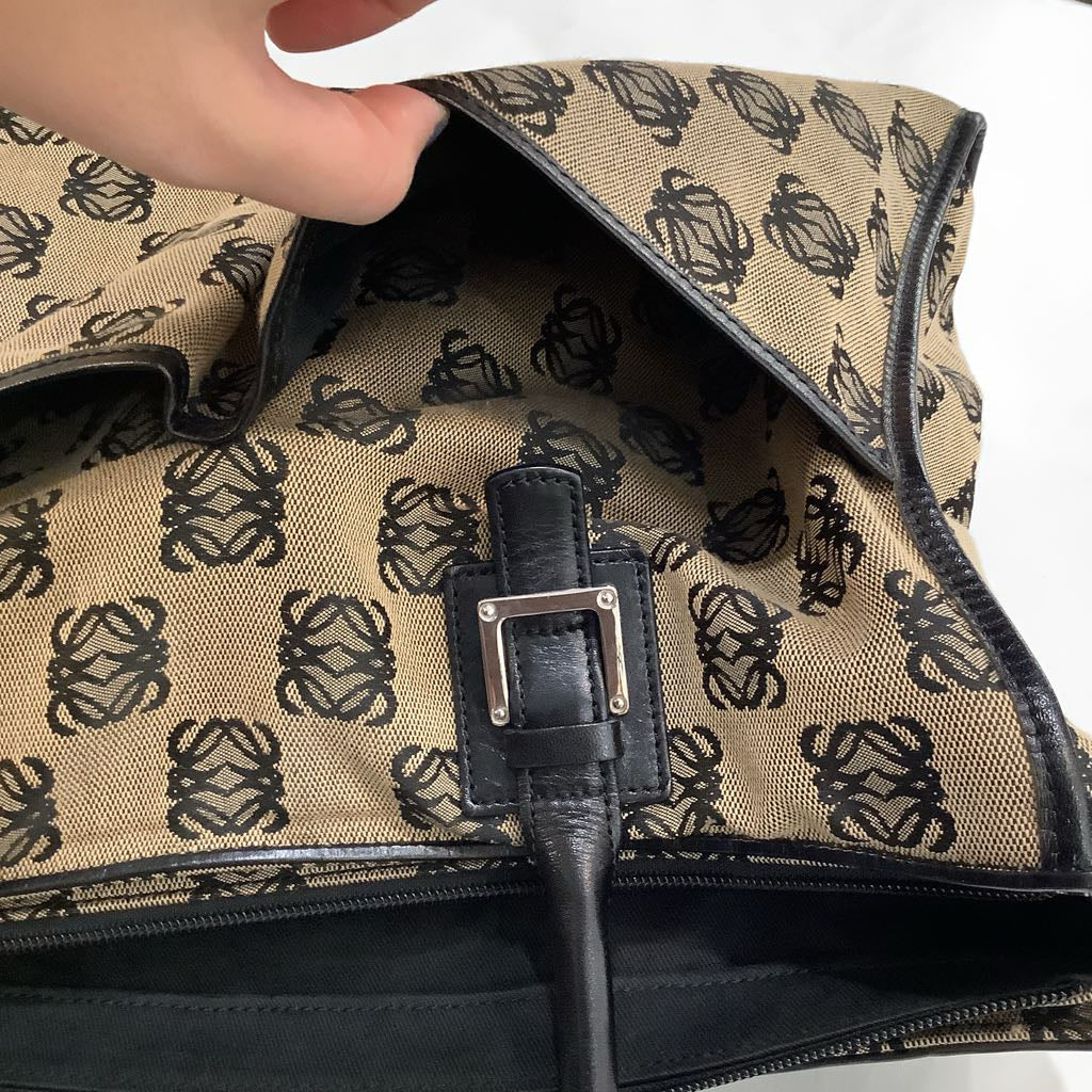 Close-up of a patterned fabric with a brand logo and a black zipper pull.