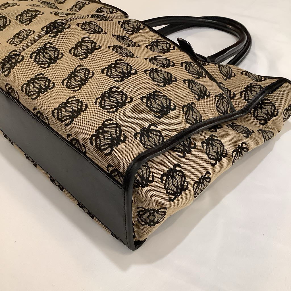 Beige handbag with black pattern on a white background