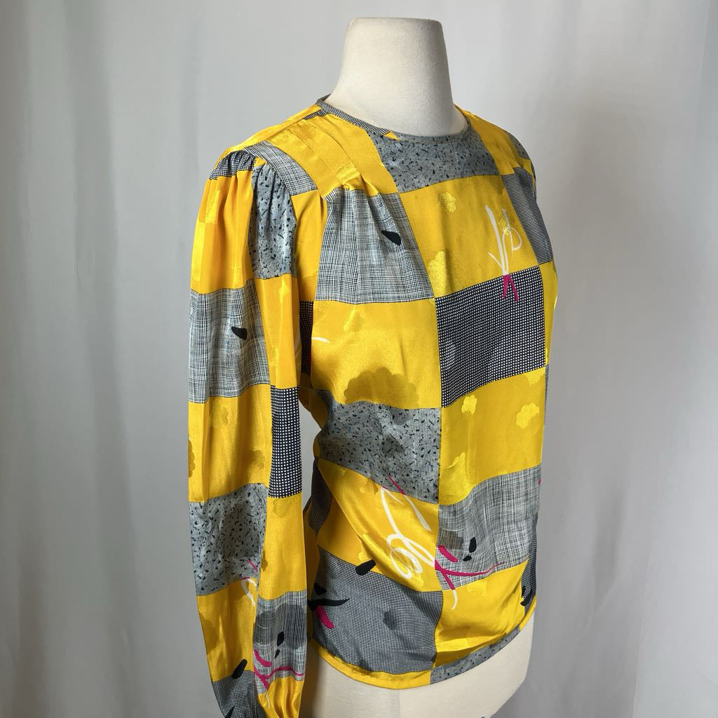 Yellow and gray patterned top on a mannequin against a plain background