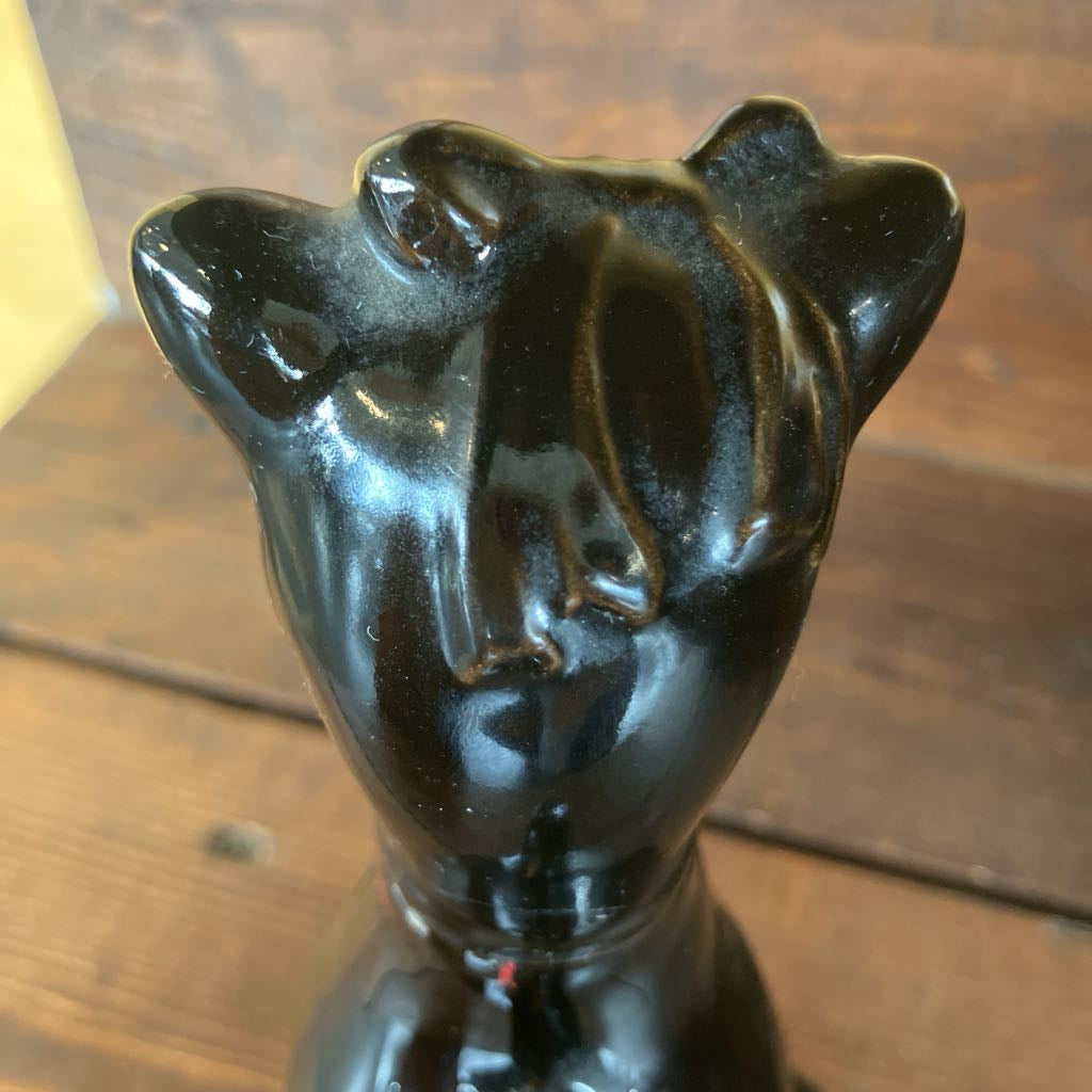 Black ceramic vase with abstract design on a wooden surface