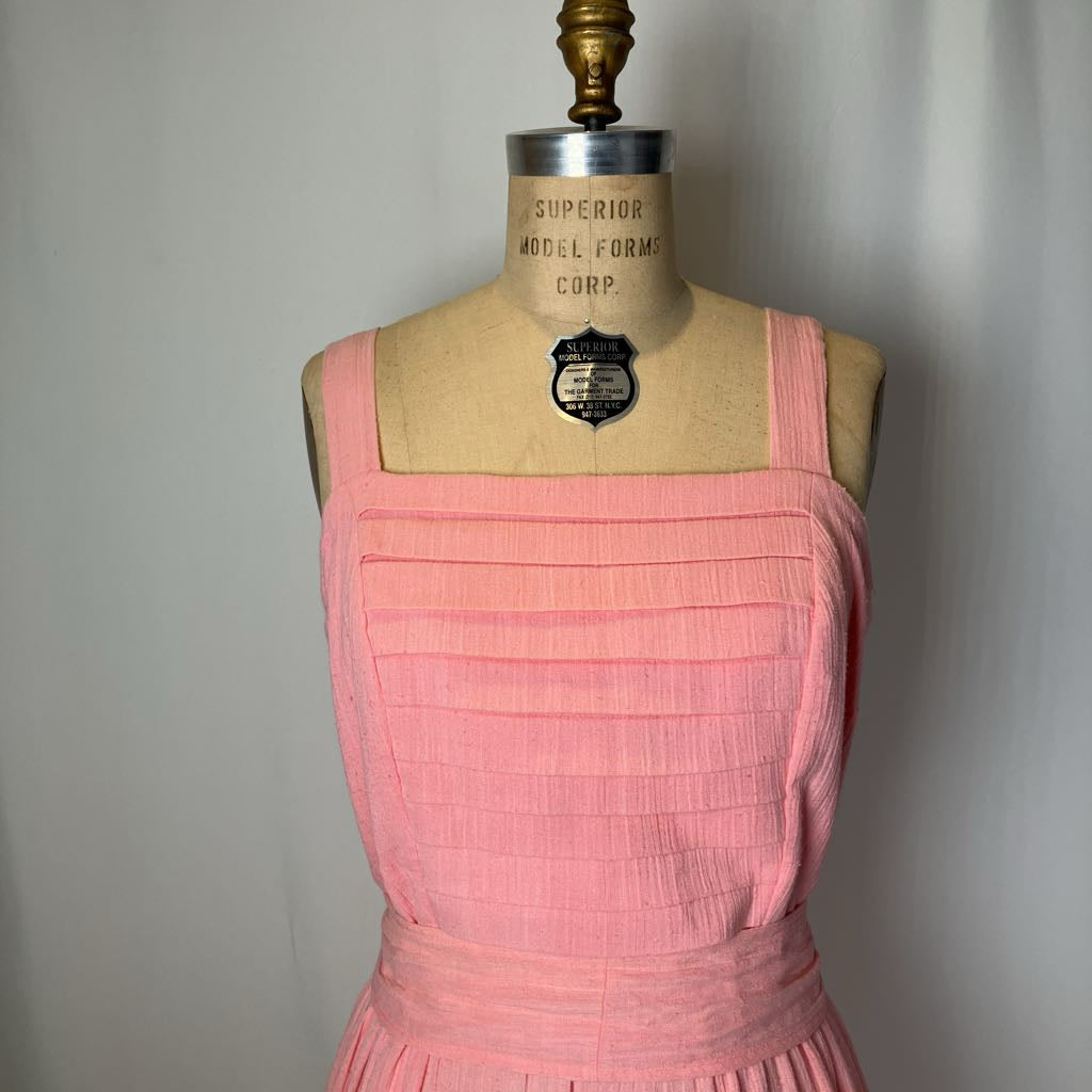 Pink dress on a mannequin with 'Superior Model Forms Corp.' label against a plain background