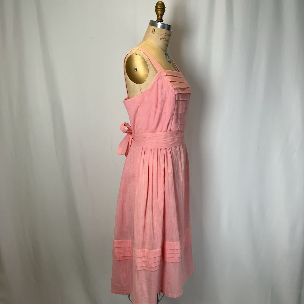 Pink dress on a mannequin against a plain background