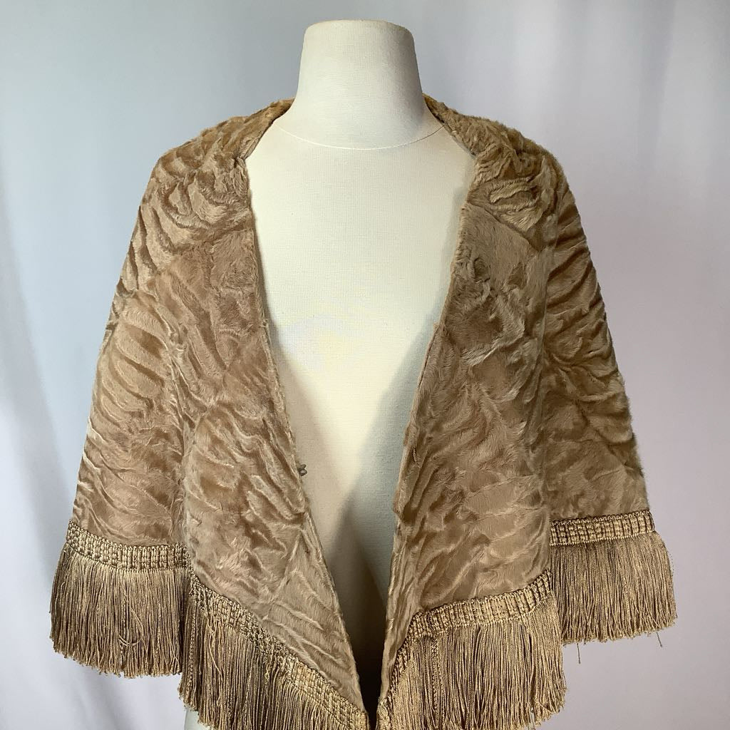 Beige textured shawl with fringe on a mannequin against a plain background