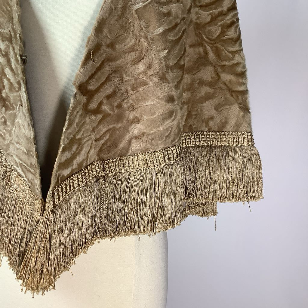 Close-up of a textured fabric with fringes on a mannequin against a white background