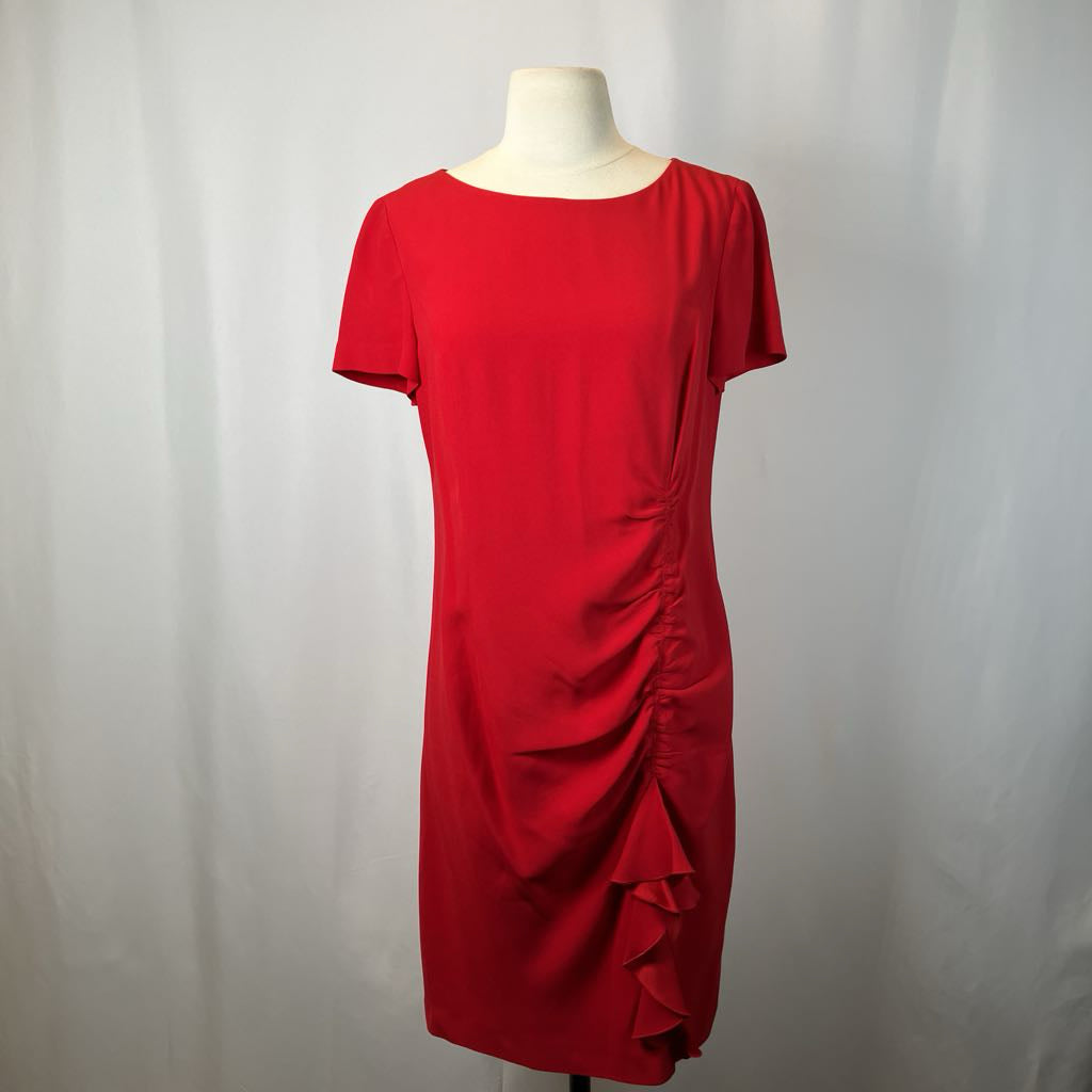 Red dress on a mannequin against a plain background