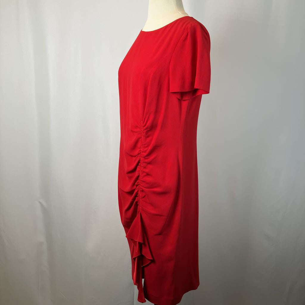 Red dress on a mannequin against a plain background