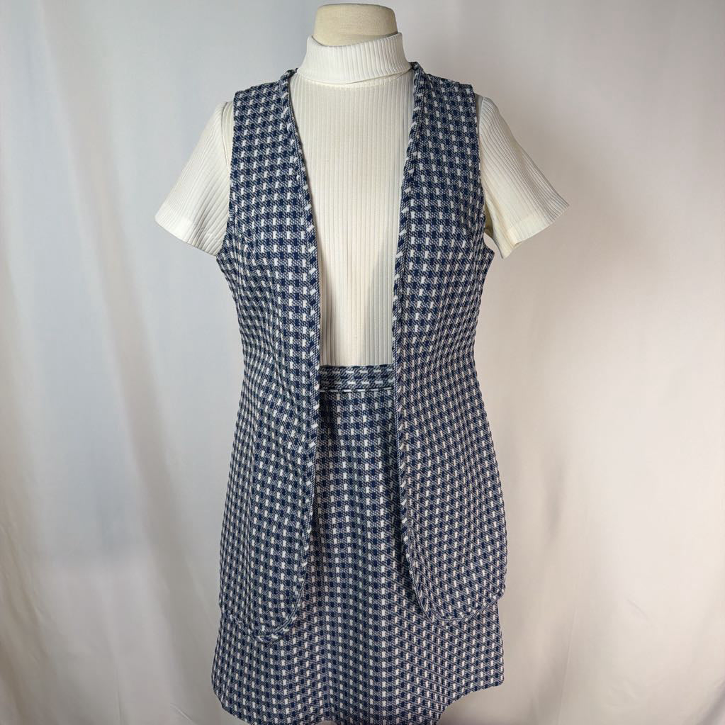 Blue houndstooth patterned vest over a white turtleneck on a mannequin against a plain background