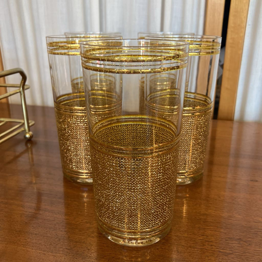 Set of gold embossed glasses on a wooden surface