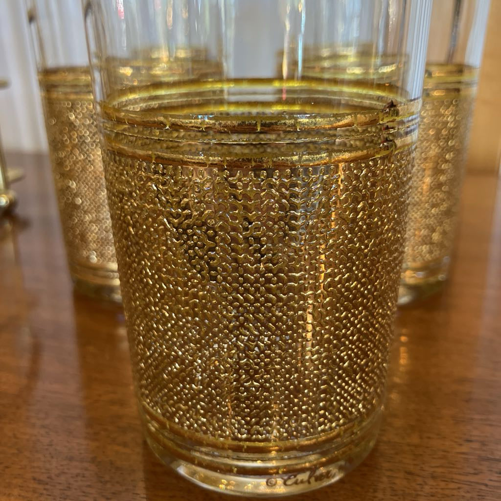 Up-close shot of gold embossed glasses on a wooden surface