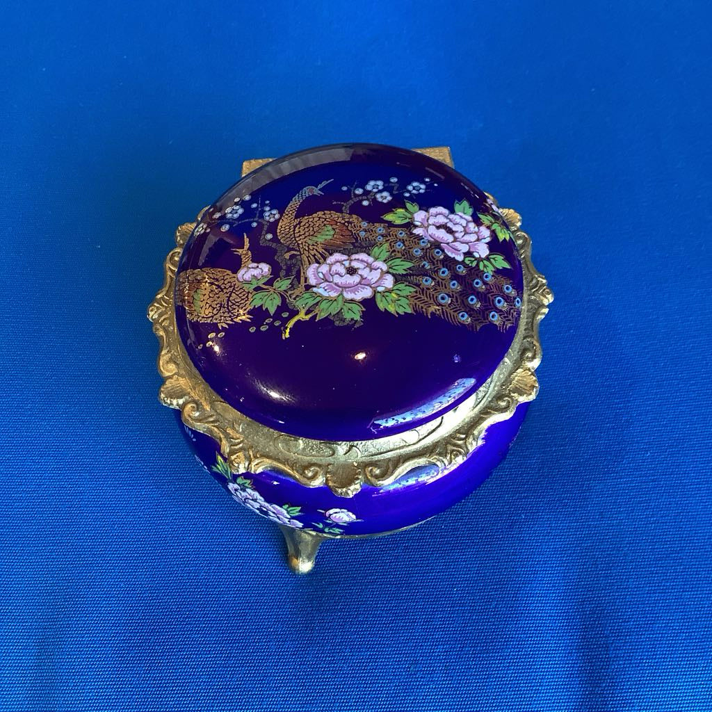 Decorative blue jewelry box with floral and bird design on a blue background