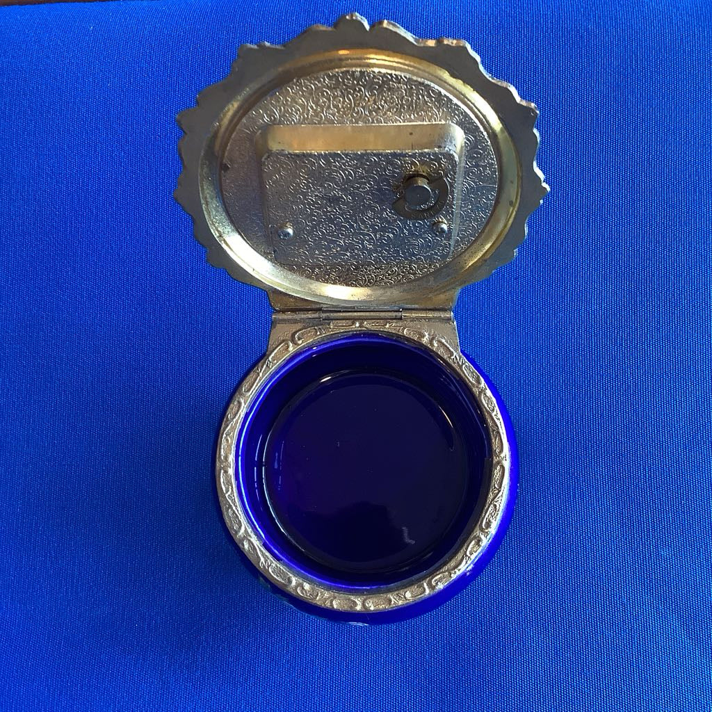 Metallic jewelry box with a blue interior on a blue background
