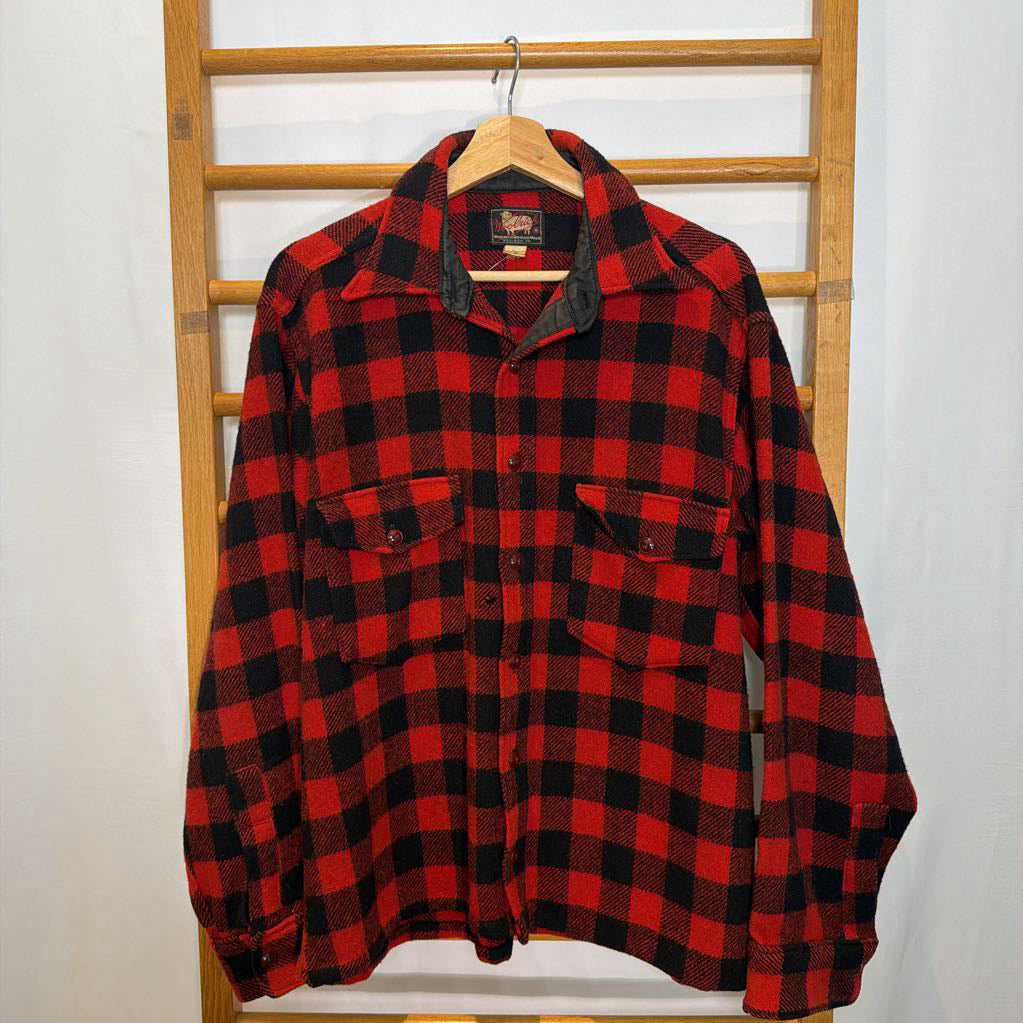 A red plaid long sleeved shirt on a wooden rack.