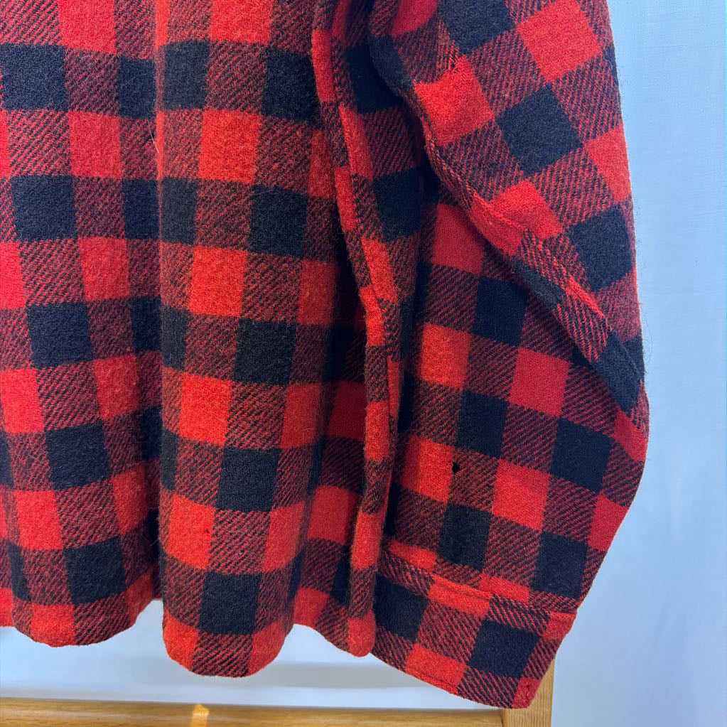 A red plaid long sleeved shirt on a wooden rack.
