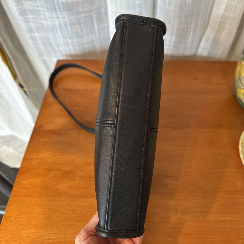 Black leather glove on a wooden surface with a blurred background