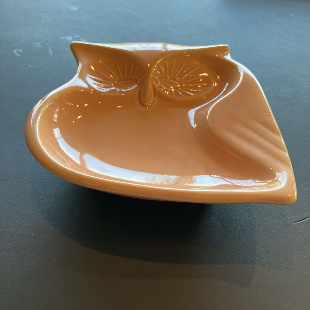 Orange owl-shaped dish on a dark surface