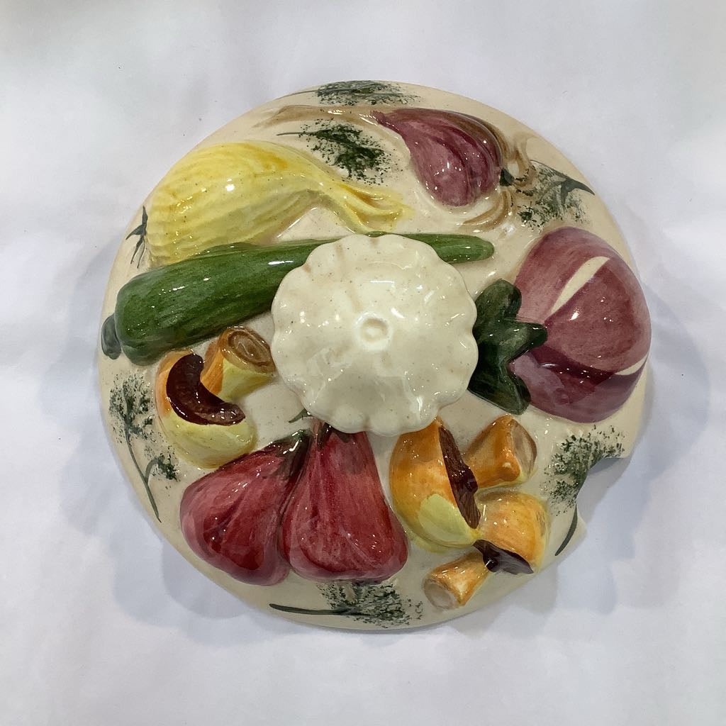 Decorative ceramic plate with colorful fruit and vegetable design on a white background