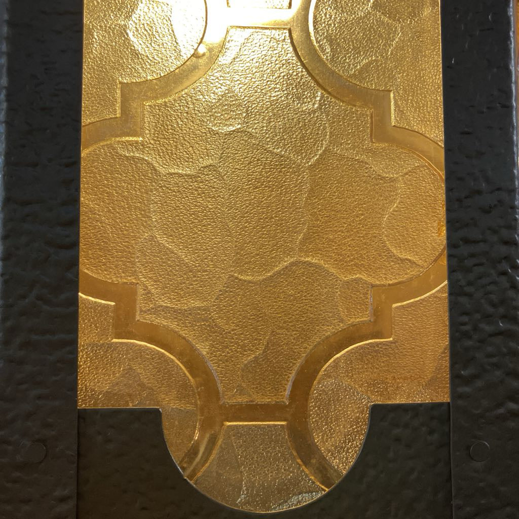 Decorative gold panel with intricate patterns on a black background