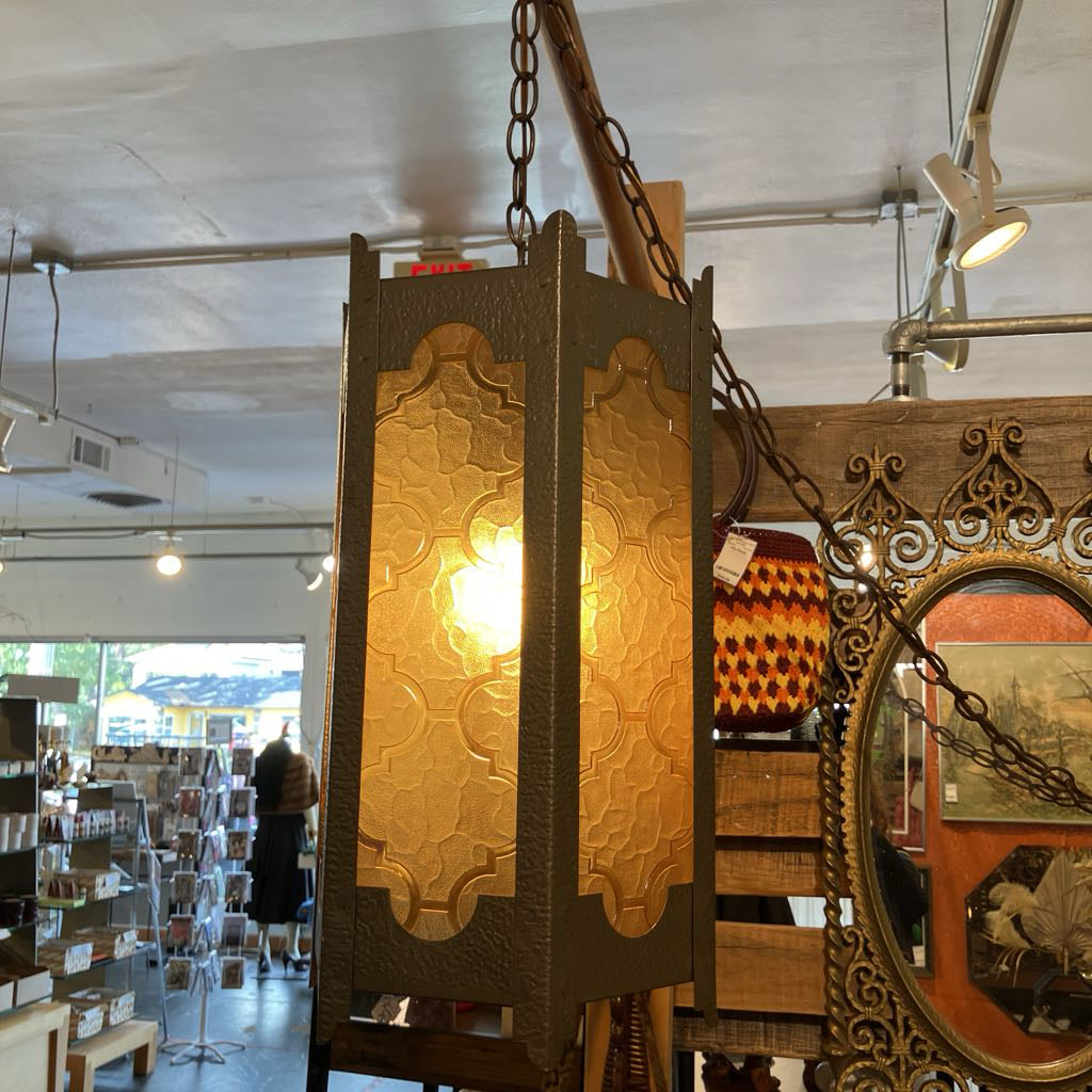 Decorative pendant light with intricate design in a store setting