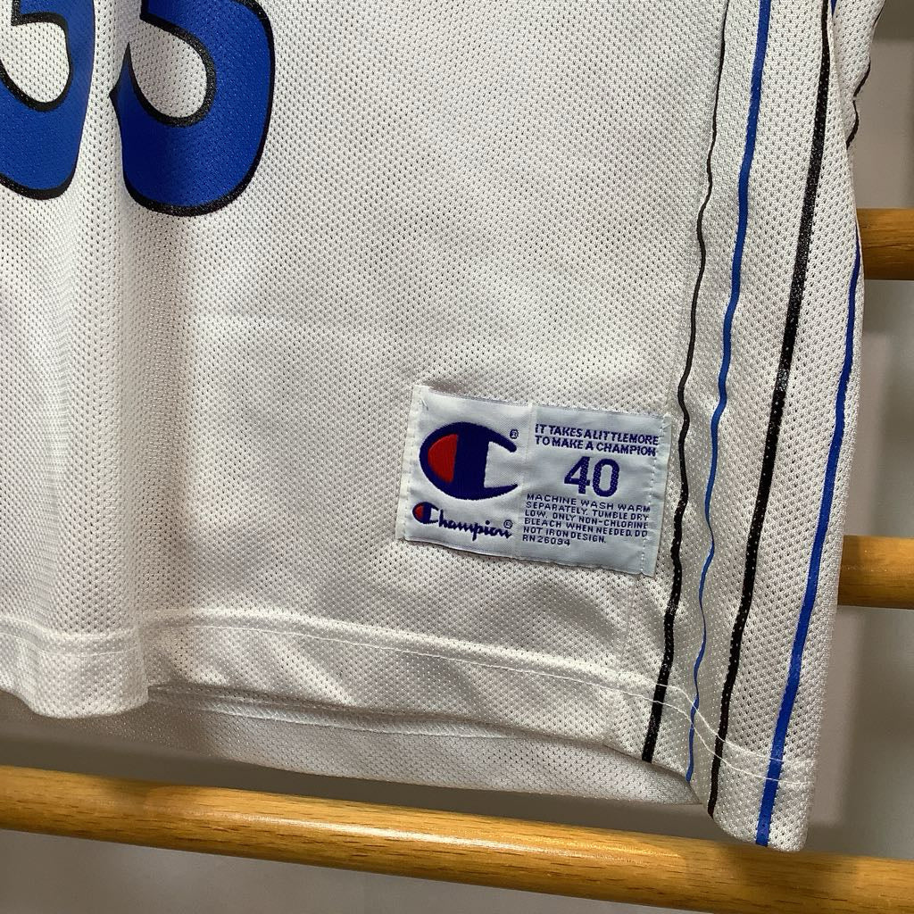 Close-up of a Champion sports jersey with a tag on a wooden hanger