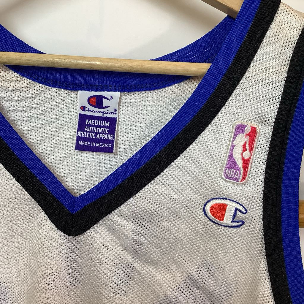 Close-up of a Champion basketball jersey with NBA logo on a hanger