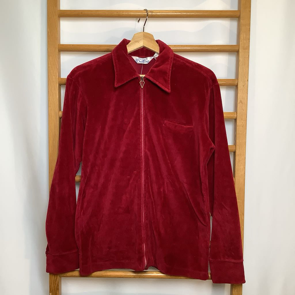Red velvet jacket hanging on a wooden rack against a white wall