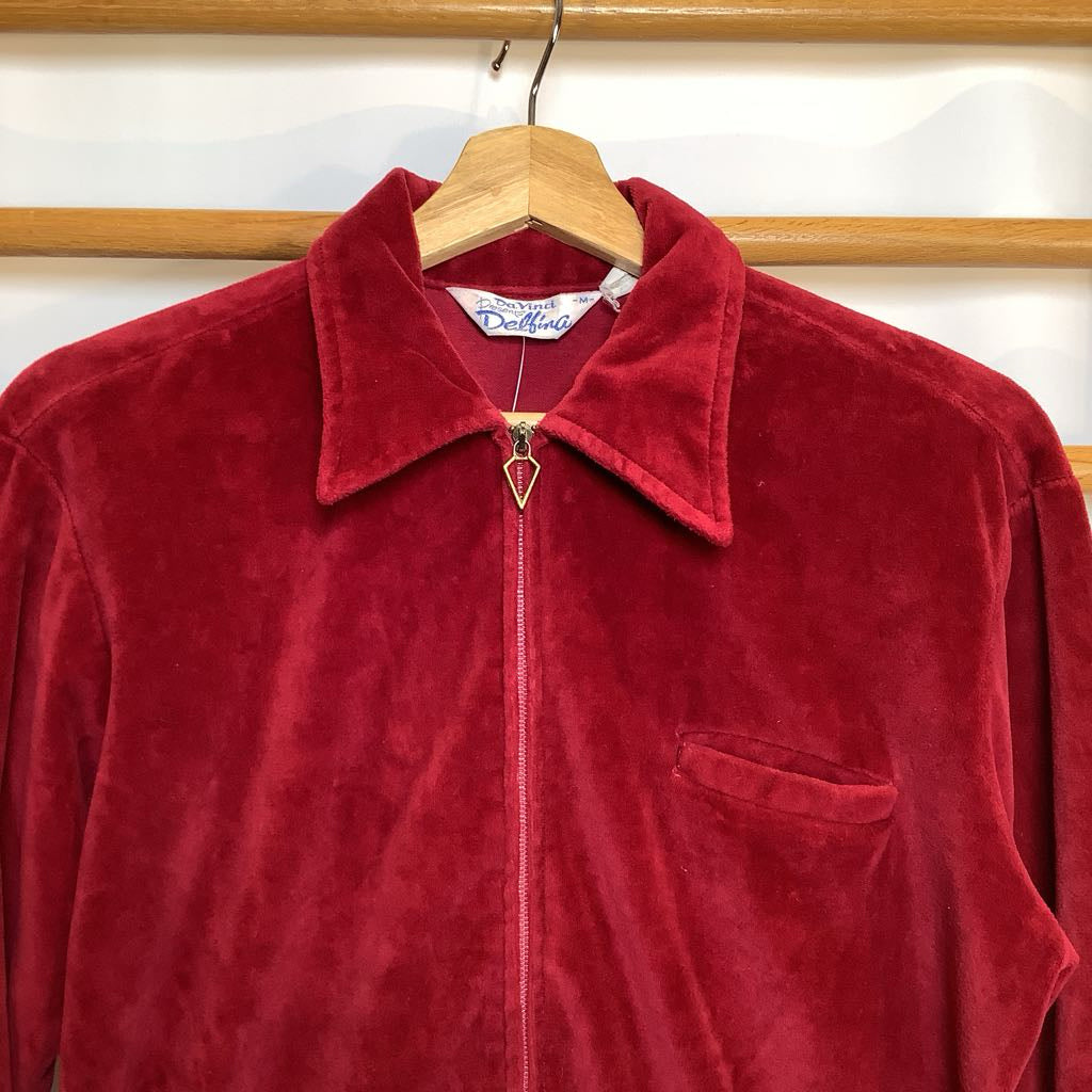 Red velvet jacket on a hanger with a visible brand label.