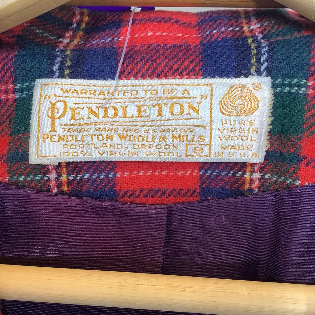 Pendleton label on a plaid fabric with a wooden frame in the background