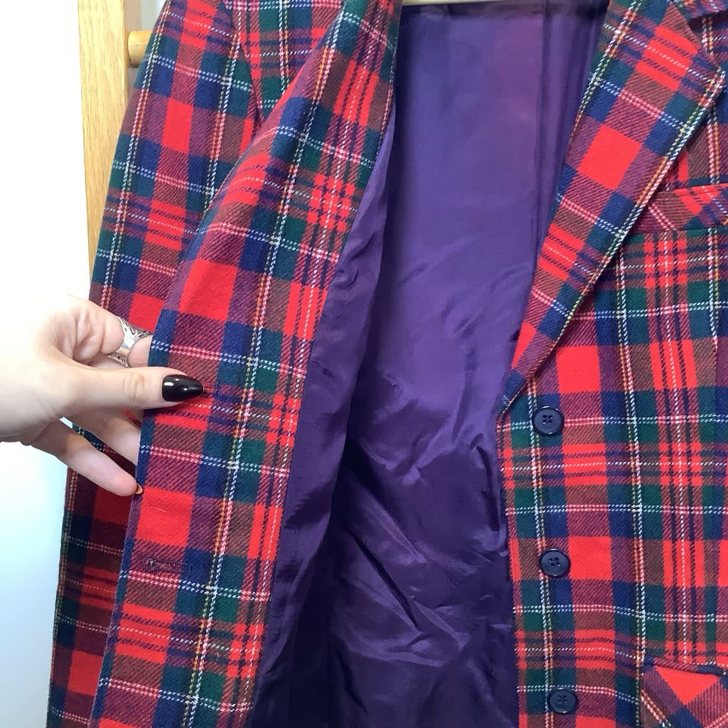 Plaid jacket with a purple lining held by a hand