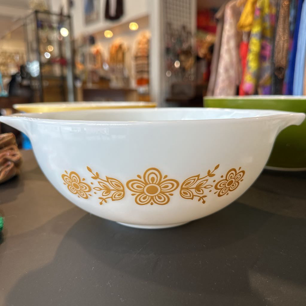 White bowl with gold floral patterns on a dark surface, blurred background