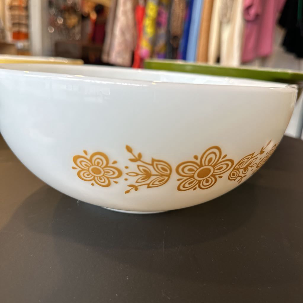 White bowl with gold floral patterns on a dark surface, blurred background