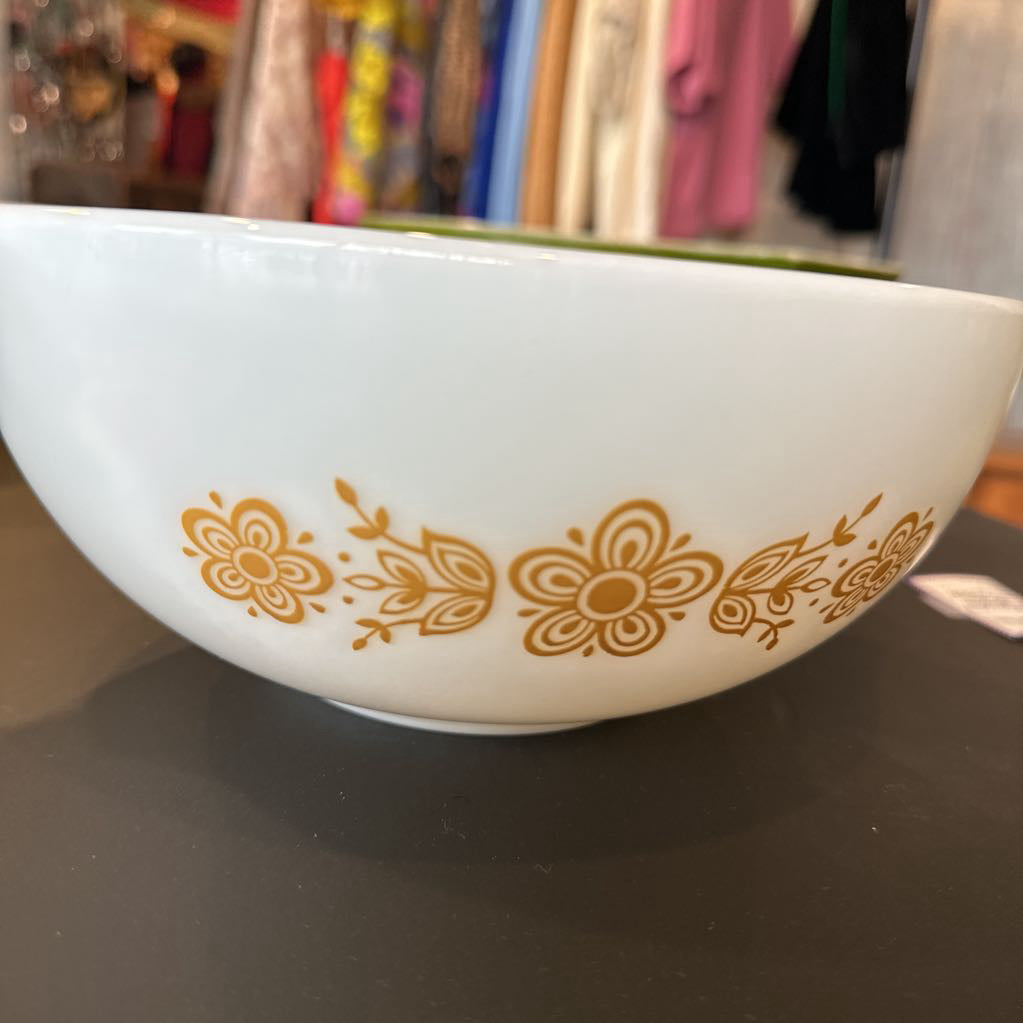 White bowl with gold floral patterns on a dark surface