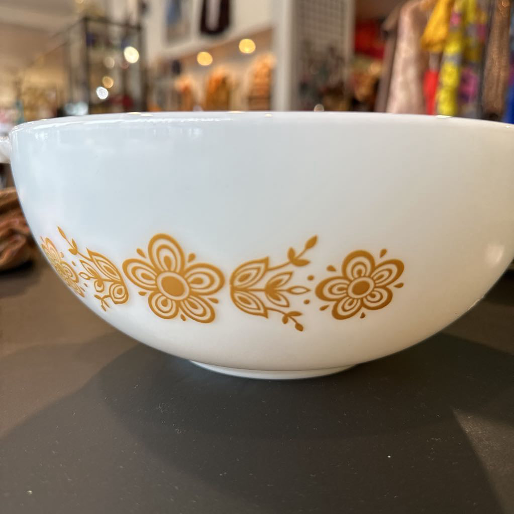 White bowl with gold floral patterns on a dark surface, blurred background