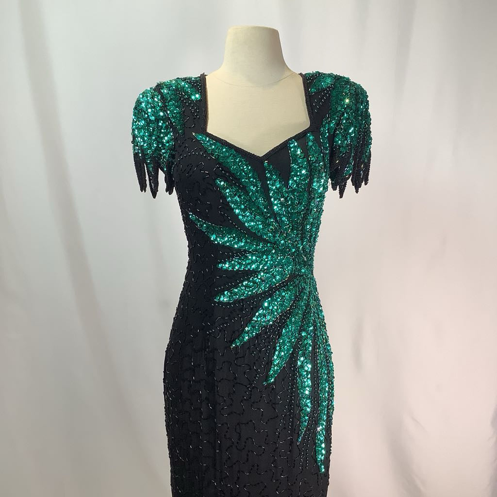Black and green sequin dress on a mannequin against a white background