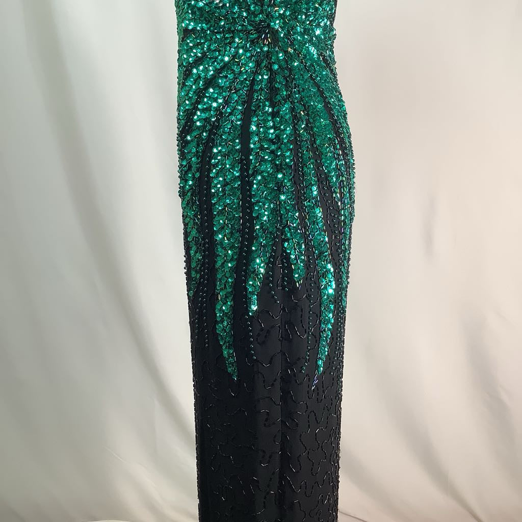 Black evening gown with green sequin detailing on a white background