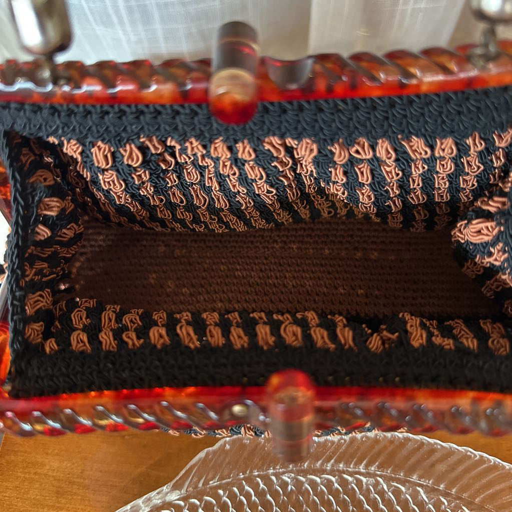 Close-up of a black and gold patterned fabric with a red border.